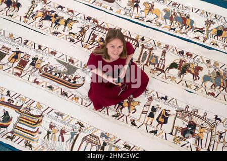 Mia Hansson con la sua replica full-size del Bayeux Tapestry a Wisbech, Cambridgeshire, che finora ha preso quasi sei anni per cucire, con mia che passa fino a 10 ore al giorno lavorando su di esso a casa sua a Wisbech. L'insegnante della scuola elementare di 47 anni ha superato la metà di gennaio di quest'anno, avendo realizzato 34,2 metri (112 piedi) di opere d'arte di 68,38 metri (224 piedi), che saranno esposte presso la St Peter's Church Hall di Wisbech il 12 aprile. Data immagine: Martedì 15 febbraio 2022. Foto Stock