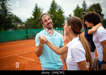 Gruppo di giocatori di tennis che danno una stretta di mano dopo una partita Foto Stock