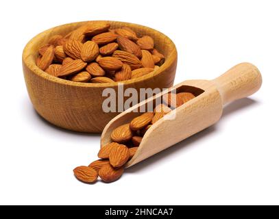 Cucchiaio di legno e ciotola piena di mandorle noci isolate su sfondo bianco Foto Stock