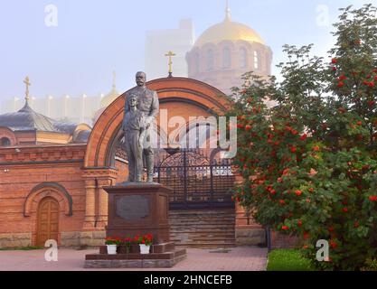 Novosibirsk, Siberia, Russia-08.15.2021: Statua dell'ultimo imperatore russo sullo sfondo dell'arco d'ingresso, la cupola dorata del tempio in t Foto Stock