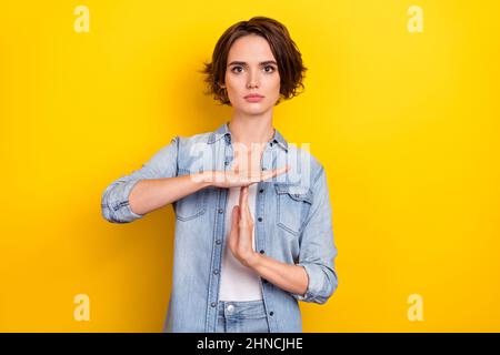 Foto di giovane donna mostra mani stop simbolo difesa Trainee limite isolato su sfondo giallo Foto Stock