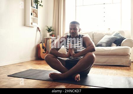 I vostri pensieri controllano la vostra vita. Scatto di un giovane sportivo che medita a casa. Foto Stock