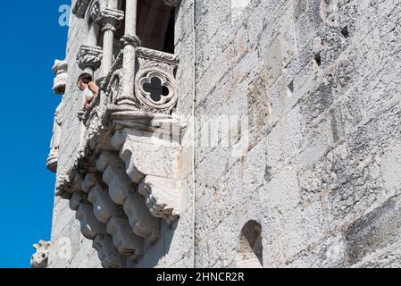 Turista femminile che guarda da un balcone della Torre di Belem (Torre de Belem). Lisbona, Portogallo Foto Stock