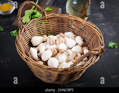 Funghi di ostrica crudi pleurotus eryngii in basket su sfondo scuro Foto Stock