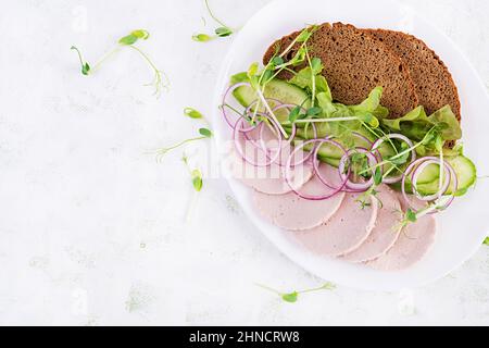 Sandwich con salsiccia di pollo fatta in casa, lattuga e cetriolo nel piatto. Vista dall'alto, sopra Foto Stock