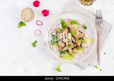 Insalata di funghi di ostriche con semi di sesamo, ravanello e lattuga su un piatto. Pleurotus eryngii. Vista dall'alto Foto Stock