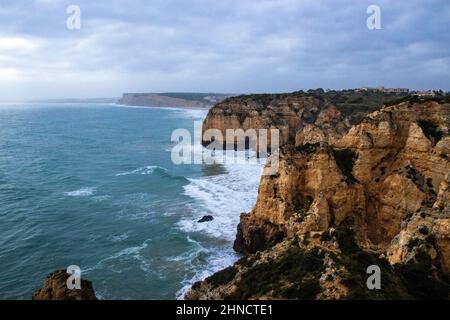 Scenario di Algarve, Lagos in tempo tempesta con onde che si infrangono contro le scogliere Foto Stock