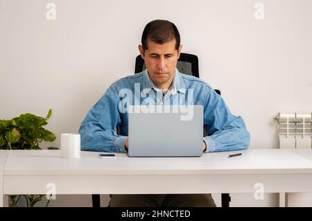 Scatto corto di un bel giovane uomo d'affari che lavora sul suo laptop in ufficio a casa Foto Stock