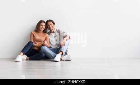 Uomo e donna soddisfatti millenni europei tiene le mani, progettando interni futuri Foto Stock