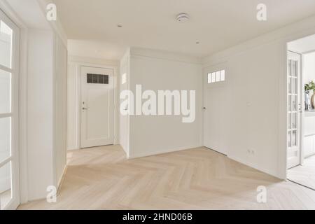 Interno di luce ampio corridoio di colore bianco con armadi e porte in vetro Foto Stock
