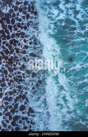 Dall'alto di potenti onde di mare scuro con schiuma bianca Foto Stock
