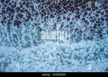 Dall'alto di potenti onde di mare scuro con schiuma bianca Foto Stock