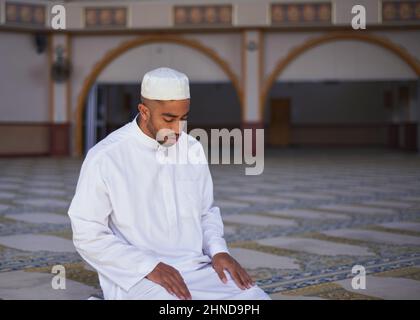 Un uomo musulmano si inchina in una moschea Foto Stock