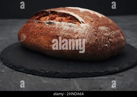 Primo piano con pane rotondo di segale appena sfornato. Pane fatto in casa. Il concetto di alimentazione sana. Foto Stock