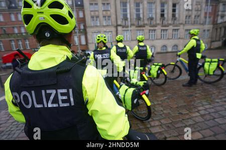 Kiel, Germania. 16th Feb 2022. I poliziotti della prima squadra di biciclette della polizia di Kiel sono in piedi sulla piazza del municipio con i loro pedelec in colori della polizia. In futuro, sei poliziotti saranno in pattuglia nella capitale dello stato in bicicletta. Credit: Marcus Brandt/dpa/Alamy Live News Foto Stock