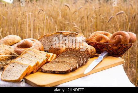 lotto di pane, grano, segale aromatizzato, sulla tavola all'esterno del campo Foto Stock