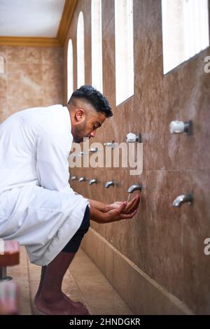 Un giovane musulmano si esibisce durante le preghiere Foto Stock