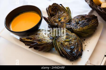 Carciofi cotti su carciali con romesco Foto Stock