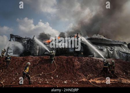 Dana, Siria. 16th Feb 2022. I membri della Difesa civile siriana, noti come caschi bianchi, lavorano per estinguere un incendio scoppiato in un deposito di combustibile a seguito di un attacco missilistico da parte del regime siriano e delle forze russe al villaggio di Tarminin vicino alla città di Dana. Secondo i caschi bianchi, quattro civili sono stati uccisi e altri due sono stati feriti in una baracca di artiglieria su un mercato del carburante presumibilmente affiliato ad un gruppo jihadista. Credit: ANAS Alkharboutli/dpa/Alamy Live News Foto Stock