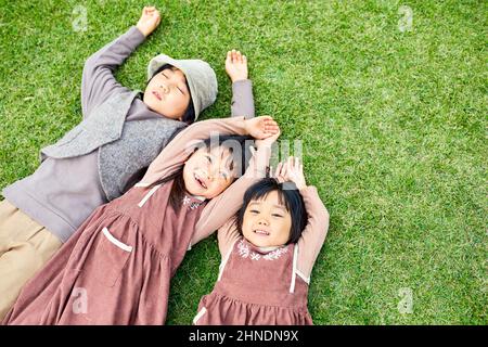 Fratello e sorella giapponese che posano sul prato Foto Stock