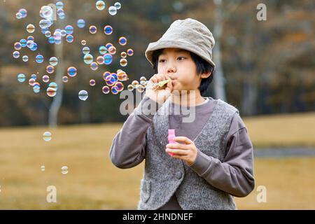 Ragazzo giapponese giocando con bolle di sapone Foto Stock