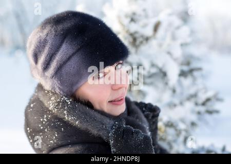 Ritratto donna di 40 anni in abiti invernali su sfondo di neve. Foto Stock