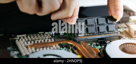 tecnico che installa il modulo di memoria ram nella scheda madre del notebook. aggiornamento hardware del computer. spazio di copia Foto Stock