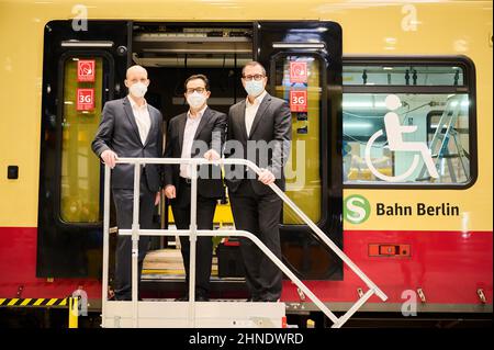 Berlino, Germania. 16th Feb 2022. Elmar Zeiler (l-r), capo dei treni Commuter e regionali presso Siemens Mobility, Peter Buchner, presidente della S-Bahn di Berlino e Jure Mikolcic, CEO Stadler Germany, si trovano di fronte alla nuova serie S-Bahn presso lo stabilimento di Berlino di Stadler. La serie 483/484 è già in parte in esecuzione sulle linee S 47 e S 45 e, da luglio, anche sulla S 46 tra Königs Wusterhausen e Westend. Credit: Annette Riedl/dpa/Alamy Live News Foto Stock