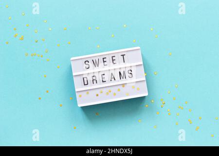 Testo della scatola luminosa sogni dolci e stella d'oro su sfondo di carta blu. Concetto buona notte biglietto d'auguri vista dall'alto Creative Flat Lay. Foto Stock