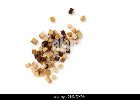mucchio di crostini fatti in casa isolati su sfondo bianco, vista dall'alto, cubetti di pane croccante, crostini di segale secca e grano, crouoton o cracker arrostiti Foto Stock