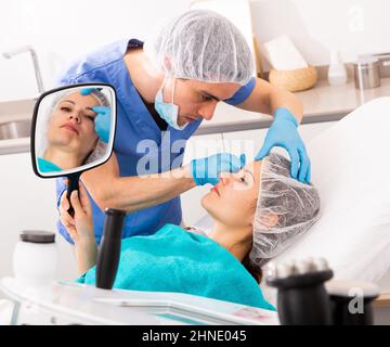 Cosmetologo che dà la consultazione alla paziente della donna Foto Stock