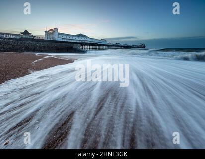 Molo di Brighton all'alba con onde tempestose che si infrangono su una spiaggia di ghiaia, Brighton, East Sussex, Inghilterra, Regno Unito, Europa Foto Stock