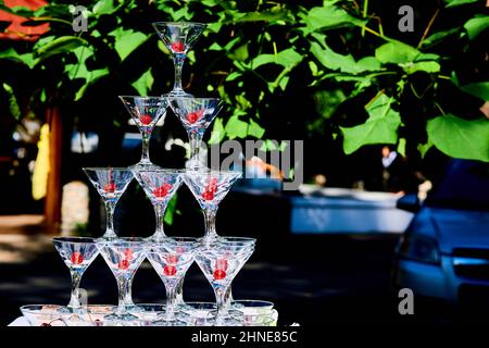 Un vetrino di bicchieri da cocktail con frutti di bosco in una calda giornata di festa Foto Stock