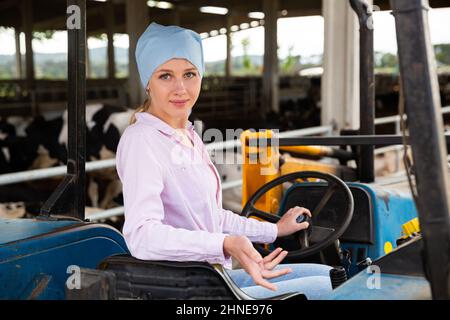 Agricoltore donna che lavora sul trattore Foto Stock