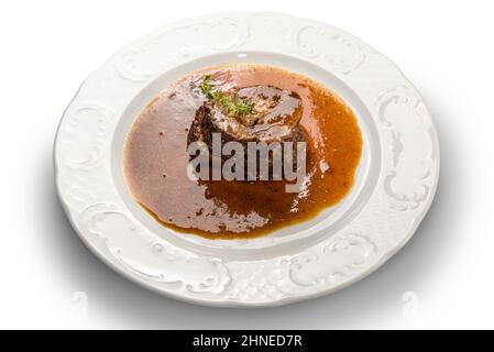 Manzo brasato in vino rosso in piatto bianco isolato su bianco Foto Stock