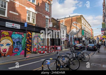 Assapora l'arte Graffiti in Hanbury Street, nei pressi di Brick Lane, l'iconica London Street, sede della comunità del Bangladesh conosciuta per i suoi ristoranti al curry, ora alla moda Foto Stock