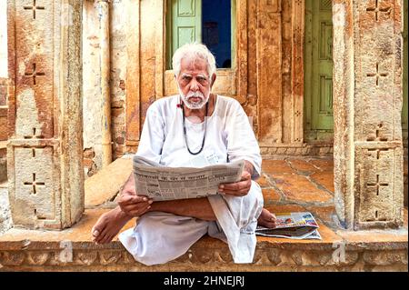 India Rajasthan jaisalmer. Un uomo che legge un giornale per strada Foto Stock