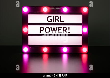 Scatola luminosa con luci rosa in camera oscura con parole - ragazza potere! Foto Stock