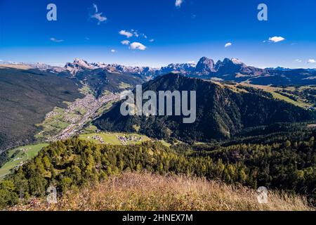 Veduta aerea della Val Gardena e del comune di Ortisei, del gruppo Odle, del gruppo Sella e del Sassolungo in lontananza, vista da Puflatschspitz a Seiser Alm. Foto Stock