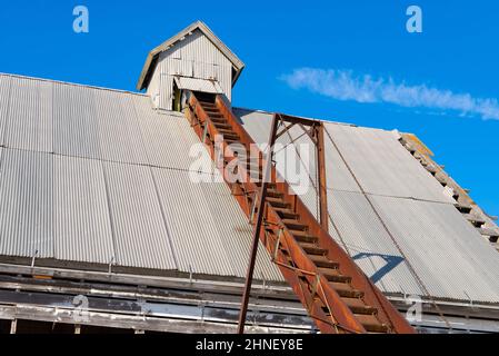 Trasportatore arrugginito su vecchio fienile vintage in Illinois rurale. Foto Stock