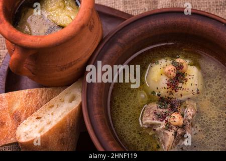 Shurpa in una ciotola di argilla da vicino, con pane piatto Foto Stock