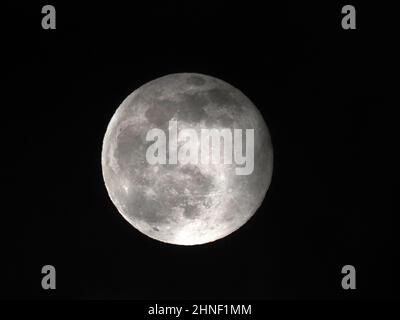 Sheerness, Kent, Regno Unito. 16th Feb 2022. UK Weather: La luna piena neve vista attraverso le lacune nella copertura nuvola sopra Sheerness, Kent questa sera. Credit: James Bell/Alamy Live News Foto Stock