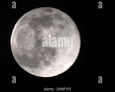 Sheerness, Kent, Regno Unito. 16th Feb 2022. UK Weather: La luna piena neve vista attraverso le lacune nella copertura nuvola sopra Sheerness, Kent questa sera. Credit: James Bell/Alamy Live News Foto Stock