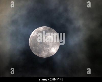 Sheerness, Kent, Regno Unito. 16th Feb 2022. UK Weather: La luna piena neve vista attraverso le lacune nella copertura nuvola sopra Sheerness, Kent questa sera. Credit: James Bell/Alamy Live News Foto Stock