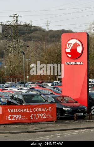 Treforest, Galles - Febbraio 2022: Segno fuori di una concessionaria Vauxhall auto con auto usate in vendita parcheggiata sul piazzale garage Foto Stock