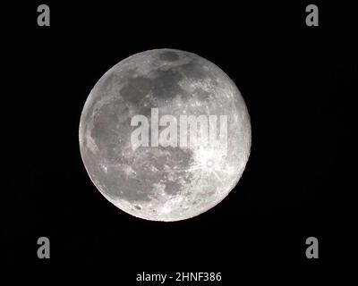 Sheerness, Kent, Regno Unito. 16th Feb 2022. UK Weather: La luna piena neve vista attraverso le lacune nella copertura nuvola sopra Sheerness, Kent questa sera. Credit: James Bell/Alamy Live News Foto Stock