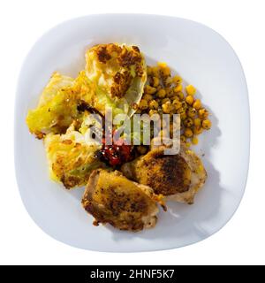 Vista dall'alto delle cosce di pollo arrosto con cavolo in pastella, ceci e salse Foto Stock