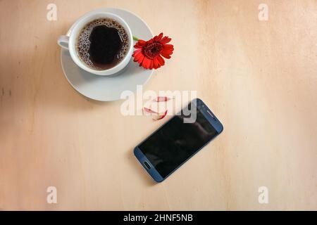 Telefono cellulare, tazza di caffè e un fiore rosso con petali strappati come sì o no oracle, amore e datazione chiamata concetto, sfondo di legno chiaro, spazio copia, h Foto Stock
