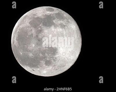 Sheerness, Kent, Regno Unito. 16th Feb 2022. UK Weather: La luna piena neve vista attraverso le lacune nella copertura nuvola sopra Sheerness, Kent questa sera. Credit: James Bell/Alamy Live News Foto Stock