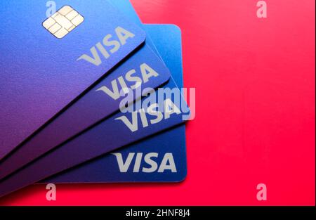 Pila di carte di debito VISA poste su sfondo vibrante con spazio negativo. Messa a fuoco selettiva. Stafford, Regno Unito, 16 febbraio 2022. Foto Stock